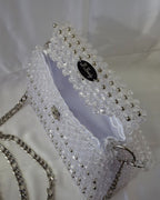 White beaded headband with silver accents on a white background
