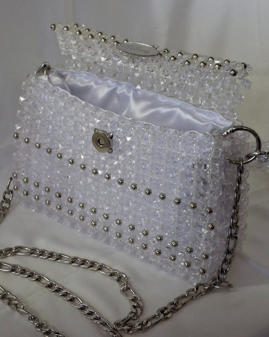 Sparkly handbag with silver chain strap on a white background